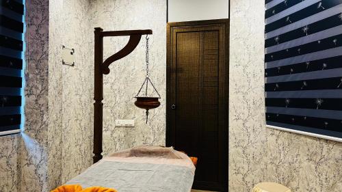 Ayur Arogyam Rooms and Spa في Kondotti: غرفة مع سرير مع مرجيحة وعلم