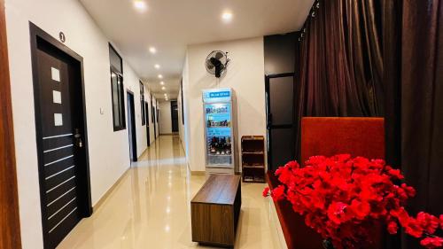 a hallway with a drink cooler and a vase of red flowers at Ayur Arogyam Rooms and Spa in Kondotti