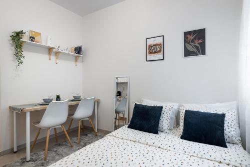 克桑西的住宿－Micro Studio 10，卧室配有一张床和一张桌子及椅子