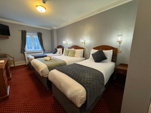 a hotel room with two beds and a window at The Killarney Grand in Killarney