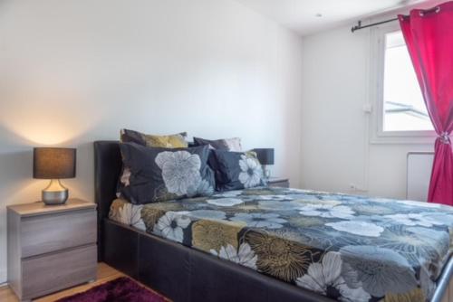 ein Schlafzimmer mit einem Bett, einem Nachttisch und einem Fenster in der Unterkunft Appartement Fuychaa Proche de Lyon , Eurexpo , stadium , Aréna in Meyzieu