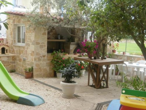 a garden with a table and chairs and flowers at Argoliki Thalassa in Míloi