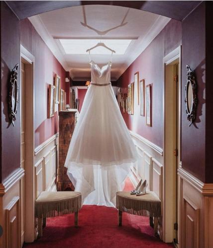 a wedding dress hanging on a rack in a room at Hotel de la Gaichel in Eischen