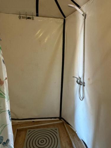 a corner of a shower in a room with a spiral at Sahara Desert Camp in Hassilabied