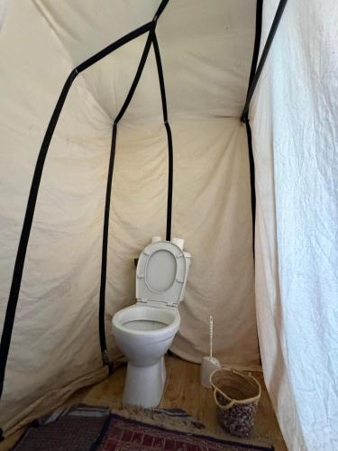 a bathroom with a toilet in a tent at Sahara Desert Camp in Hassilabied