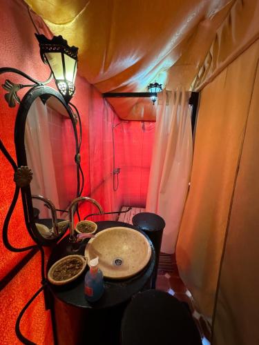 a bathroom with a sink in a tent at Sahara Desert Camp in Hassilabied
