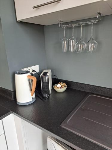 a kitchen counter with a coffee maker and glasses on the wall at Le 7 in Vieille-Toulouse