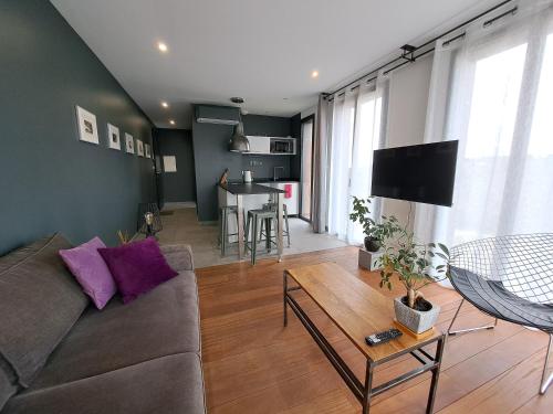 a living room with a couch and a table at Le 7 in Vieille-Toulouse