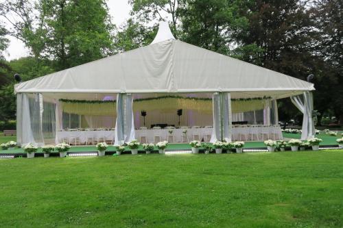 a white tent with white chairs in a field at Hotel de la Gaichel in Eischen