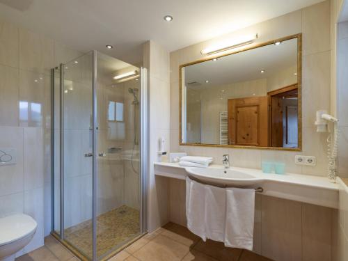 a bathroom with a shower and a sink and a mirror at Appartements Haflingerhof in Westendorf