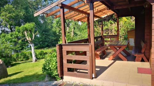 a wooden pergola with a picnic table on a patio at Domek letniskowy OLEK in Ryn