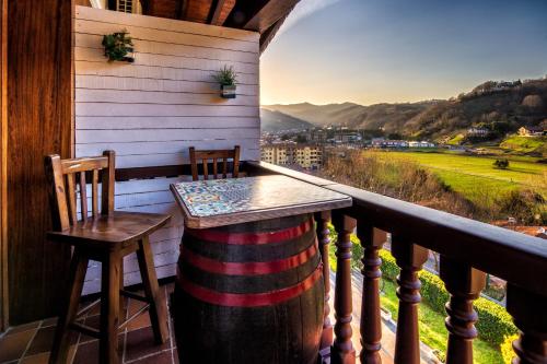 einen Tisch und zwei Stühle auf einem Balkon mit Aussicht in der Unterkunft Casa Otxotenea in Lesaka