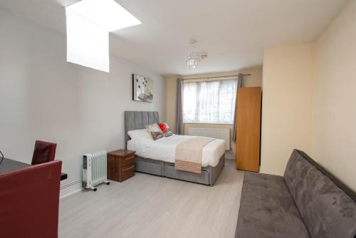 a bedroom with a bed and a couch at Saffron Studios in Orpington