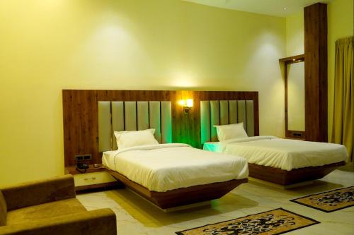 um quarto com 2 camas, uma cadeira e um espelho em HOTEL SIGNATURE INN em Ambikāpur