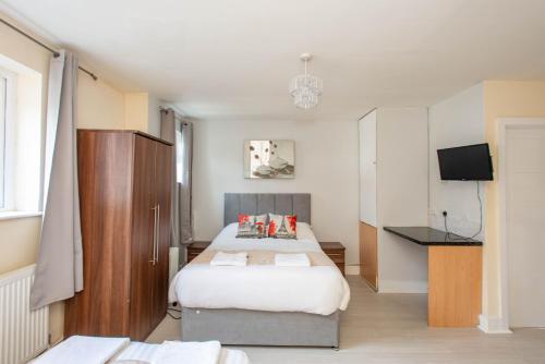 a bedroom with a bed and a television in it at Saffron Studios in Orpington