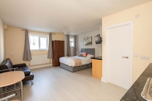 a hotel room with a bed and a table at Saffron Studios in Orpington