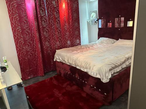 1 dormitorio con 1 cama con cortinas rojas en 1001 Nacht, en Hagen
