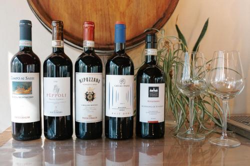 four bottles of wine sitting on a table with glasses at Borgo Il Poggio Agriturismo in Montaione