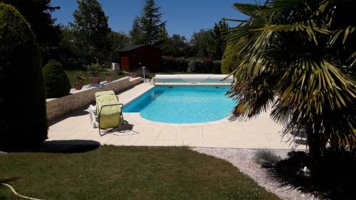 - une piscine avec 2 chaises longues à côté dans l'établissement Le Clos de Mosny, à Amboise