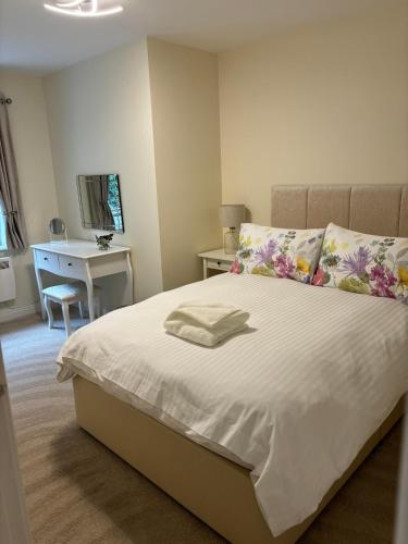 a bedroom with a white bed with a desk and a chair at Conaglen, Glenloch View, Fort William 2-Bedroom Loch Side Flat in Fort William