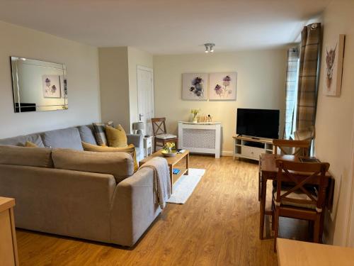 ein Wohnzimmer mit einem Sofa und einem TV in der Unterkunft Conaglen, Glenloch View, Fort William 2-Bedroom Loch Side Flat in Fort William