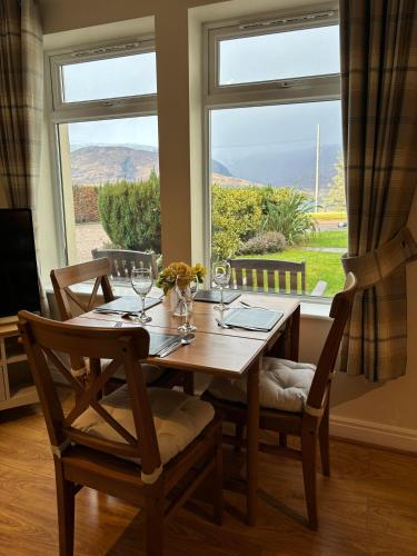 a dining room table with chairs and a large window at Conaglen, Glenloch View, Fort William 2-Bedroom Loch Side Flat in Fort William