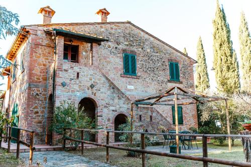 an old stone building with a fence in front of it at Borgo Il Poggio Agriturismo in Montaione