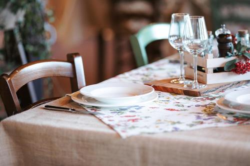 a table with plates and wine glasses on it at Borgo Il Poggio Agriturismo in Montaione
