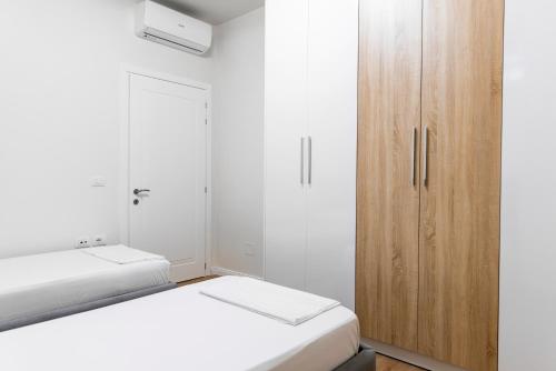 a bedroom with two beds and a wooden cabinet at JD Luxury Apartments 2 in Vlorë