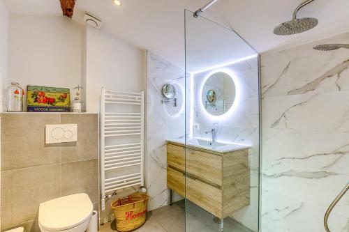 La salle de bains est pourvue d'une douche en verre et de toilettes. dans l'établissement La Demeure de Gab, à Trévoux