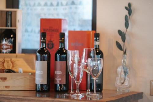 three bottles of wine sitting on a table with glasses at Borgo Il Poggio Agriturismo in Montaione