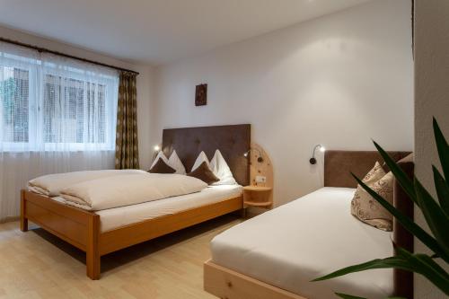 a bedroom with two beds and a potted plant at Ferienwohnung Biene - Moosbachhof in Collalbo