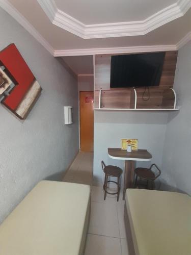 a small room with two beds and a small table at Hotel Luar in Sao Paulo