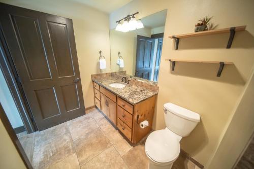 a bathroom with a toilet and a sink and a mirror at Black Bear 8053 in Keystone