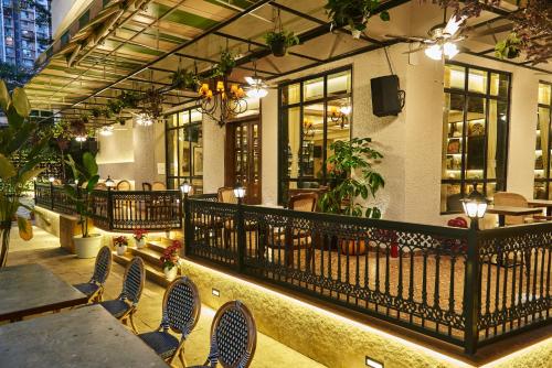 a restaurant with tables and chairs and a balcony at Arnna Hotel- Goregaon East in Mumbai