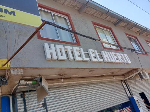 a hotel sign on the side of a building at Hotel el huerto 