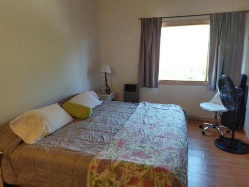 1 dormitorio con cama y ventana en La casa de Pato en San Martín de los Andes
