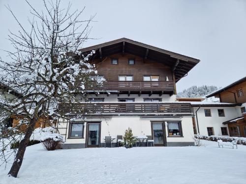 a large building with snow in front of it at Profelt`s Apartments Uttendorf - Steinbock Lodges in Uttendorf