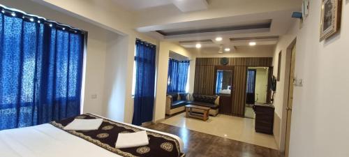 a bedroom with a bed and a chair in a room at New Phoenix By Glitz Hotels in Navi Mumbai