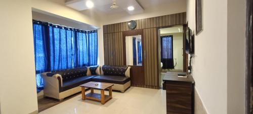 a living room with a couch and a table at New Phoenix By Glitz Hotels in Navi Mumbai