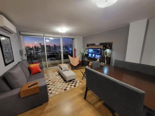 ein Wohnzimmer mit einer Couch, einem Tisch und einem Fernseher in der Unterkunft Departamento puerto Santa Fe in Santa Fe