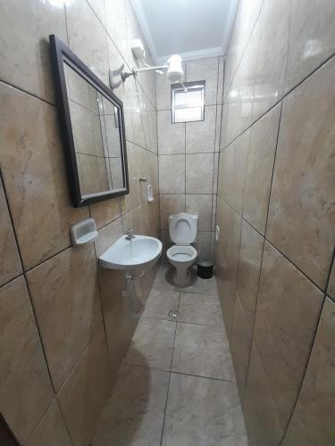 a bathroom with a toilet and a sink and a mirror at Hotel Luar in Sao Paulo