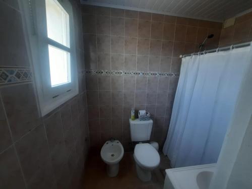 uma casa de banho com um WC, um lavatório e uma janela em Monoambiente frente al mar em La Floresta