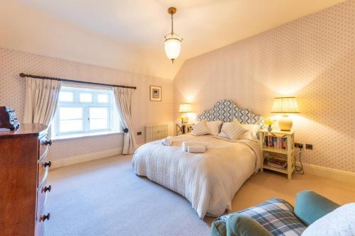 a bedroom with a large bed and a window at Pass the Keys Garden Cottage · Beautiful cottage nestled in 80 acres of parkland in Diddlebury