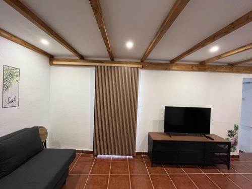 sala de estar con sofá y TV de pantalla plana en ALMAFUERTE en Mijas