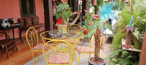 a table and chairs in a room with plants at Vila Santa Rosa in Ilhabela