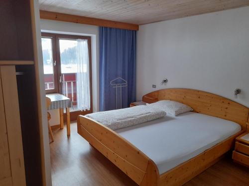 a bedroom with a wooden bed and a window at Garni Waldeck in San Giacomo