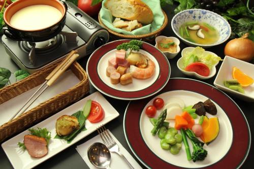 a table with plates of food and a cup of coffee at Lodge Clubman in Hachimantai