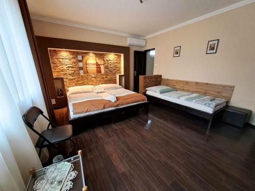 a bedroom with two beds and a brick wall at Aquacentrum in Hajdúszoboszló