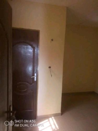 eine dunkle Holztür in einem Zimmer mit einer Wand in der Unterkunft Raski immobilier in Ouagadougou